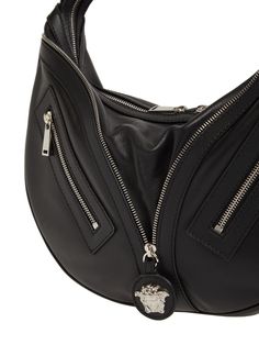 Find VERSACE Repeat Smooth Leather Hobo Bag on Editorialist. This VERSACE hobo bag features an adjustable strap, top zip closure, and a front Medusa logo zip detail. It has silver-colored hardware and measures 28cm in height, 40cm in width, and 8cm in depth. Leather Hobo Bags, Ski Accessories, Leather Hobo Bag, Strap Top, Leather Silver, Heeled Loafers, Leather Hobo, Metallic Leather, Baby Bag