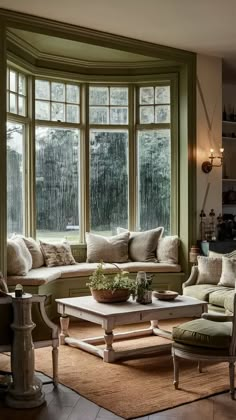 a living room filled with furniture and large windows