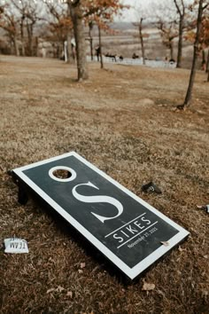 a black and white sign sitting on top of a grass covered field