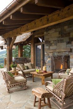 an outdoor living area with wicker furniture and stone fireplace