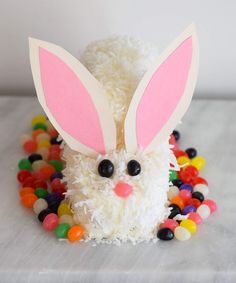 an easter bunny made out of candy and gummy balls on a white tablecloth