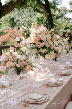 the table is set with pink and white flowers