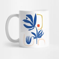 a white coffee mug with blue and orange leaves on it