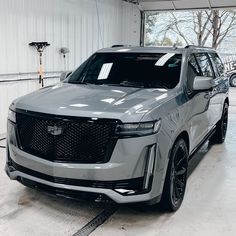 a silver suv parked in a garage next to another car