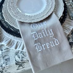 a napkin that says our daily bread on it next to some plates and silverware