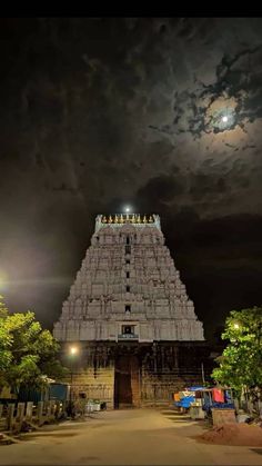 the temple is lit up at night with clouds in the sky