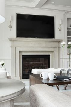 a living room filled with furniture and a flat screen tv mounted above a fire place