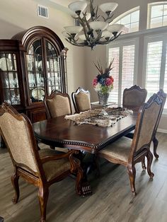 a dining room table with chairs and a china cabinet