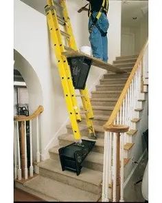 two men in blue work on the stairs