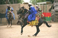 two men riding on the backs of horses