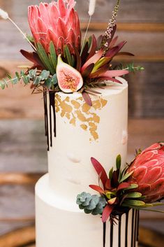 a white wedding cake with flowers and greenery