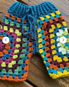 two crocheted mitts sitting on top of a wooden table next to each other