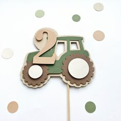 a green tractor cake topper on a stick