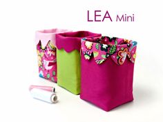 three small bags are sitting next to each other with the words lea mini on them