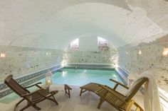 an indoor swimming pool with two lounge chairs