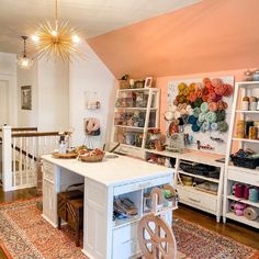 a sewing studio with lots of crafting supplies on the table and shelves full of yarn