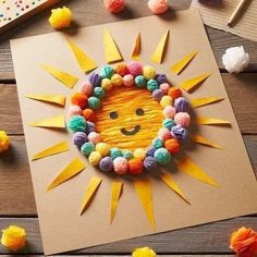 the sun is made out of yarn and paper balls on top of a piece of cardboard