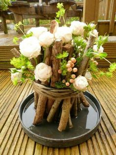 an arrangement of flowers in a basket on a wooden table with the caption crazyfours com