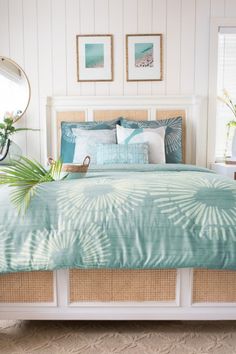 a bed in a bedroom with palm leaves on the sheets and pillows, along with two planters