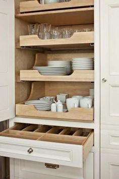 an open cabinet with dishes and glasses in the bottom drawer is shown on instagram