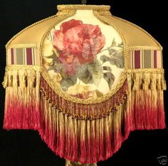 an old fashion purse with flowers and fringes on it's sides, hanging from a hook