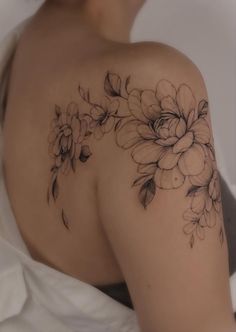 the back of a woman's shoulder with flowers on it