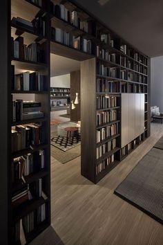 a living room filled with lots of furniture and bookshelves next to a window