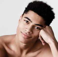 a shirtless young man with his hand on his head, looking at the camera