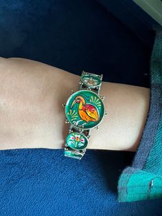 Elevate your style with our Antique Handpainted Bird Bangle, a true work of art. Crafted from high-quality brass, this bangle boasts a beautiful color combination and intricate bird design. Each stroke of paint tells a story, making this piece a unique and cherished addition to your collection. Embrace the beauty of handcrafted jewelry and wear a piece of history on your wrist. The weight of the cuff is 40 grams.  It is ideal for size 2.4- 2.6 wrist size. Inner diameter 2.25 inches. Openable wit Traditional Adjustable Enamel Bracelets, Traditional Hand Painted Adjustable Bracelets, Multicolor Bird Design Jewelry, Traditional Hand Painted Bangle Bracelet, Traditional Handmade Enamel Bangle, Hand Painted Green Bracelet As Gift, Green Enamel Bangle, Artistic Hand Painted Jewelry Bracelet, Traditional Multicolor Enamel Bracelets