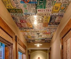 a long hallway with lots of license plates painted on the ceiling and wood paneling