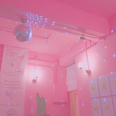 a room with pink walls and lights on the ceiling