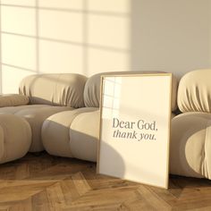 a white sign sitting on top of a wooden floor next to a beige couch and chair