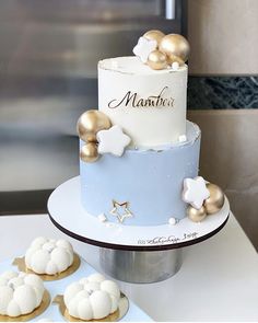 a three tiered cake sitting on top of a table next to cookies and cupcakes