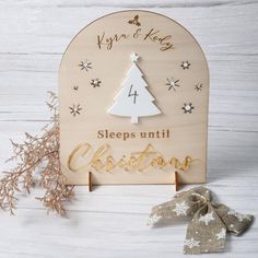 a wooden sign that says sleep until christmas with a tree on it and snowflakes