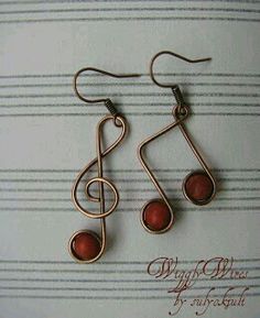 some kind of musical note earrings with red beads on it's earwires