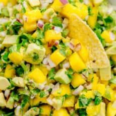 a close up of a plate of food with corn and avocado