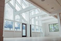 an empty room with large windows and white walls on the ceiling is seen in this image