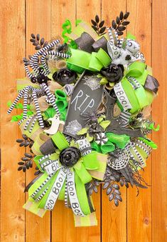 a wreath with green ribbons and monogrammed decorations on a wooden background that says happy st patrick's day