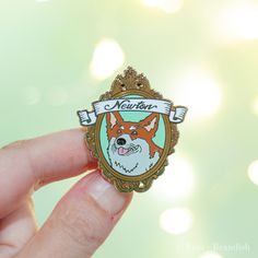 a person holding a small badge with a dog on it