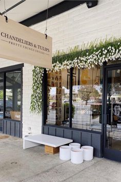 the entrance to chandler's & tulips is decorated with white flowers and greenery