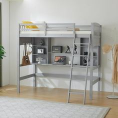 a loft bed with a desk underneath it and shelves on the bottom shelf, in front of a window