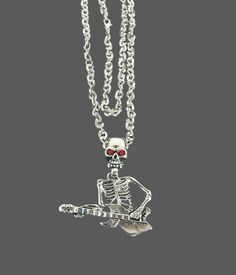 This Vampire Skull Guitar Pendant Necklace is the perfect addition to your Halloween Gothic wardrobe or for any lover of unique retro fashion jewelry. The necklace features a skeleton head in the shape of a guitar adorned with striking red eyes. This is a one-of-a-kind piece that will surely make a statement. The necklace is made with high-quality materials and is new old stock, never used. The skeleton measures approximately 9.5x3cm and weighs around 60 grams. Please note that 1 inch is equival Gothic Necklace For Halloween Concert, Punk Style Jewelry For Halloween Concert, Adjustable Necklaces For Halloween Concert, Punk Necklaces For Halloween Concert, Punk Style Necklaces For Halloween Concert, Gothic Jewelry For Halloween Concert, Gothic Halloween Jewelry For Concert, Punk Red Necklace For Halloween, Halloween Rocker Jewelry For Concert