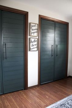 three blue doors in a room with wood floors