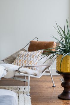 a living room filled with furniture and a potted plant on top of a chair