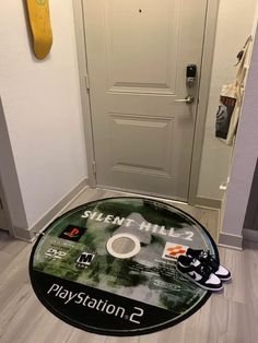 there is a playstation game on the floor in front of a door with a skateboard