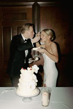 a bride and groom feeding each other cake