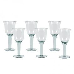 six clear wine goblets are lined up in a row