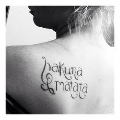 the back of a woman's shoulder with words written in cursive writing