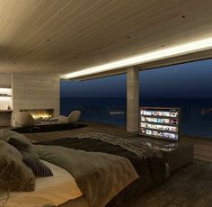 a bedroom with a large bed and a flat screen tv on the wall above it