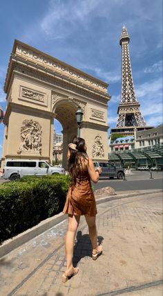 a woman is walking in front of the eiffel tower